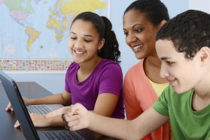 Teens with teacher at computer